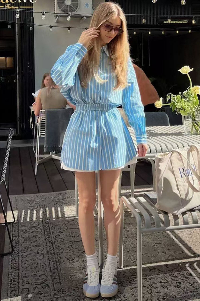 Blue - A woman wearing a blue and pale yellow vertically striped mini shirt dress featuring a collared neckline, button-down front, long sleeves, and a thick elasticated waistband.