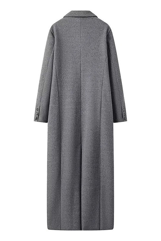 Grey - A woman wearing a long, oversized grey double-breasted maxi coat with wide lapels and flap pockets, styled for winter.