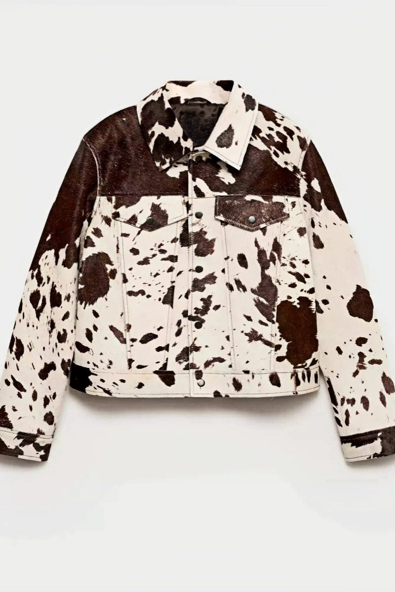 Dairy Cow - Women's western-inspired cropped trucker jacket featuring a bold brown and white cow print, pointed collar, and metallic button-front closure.