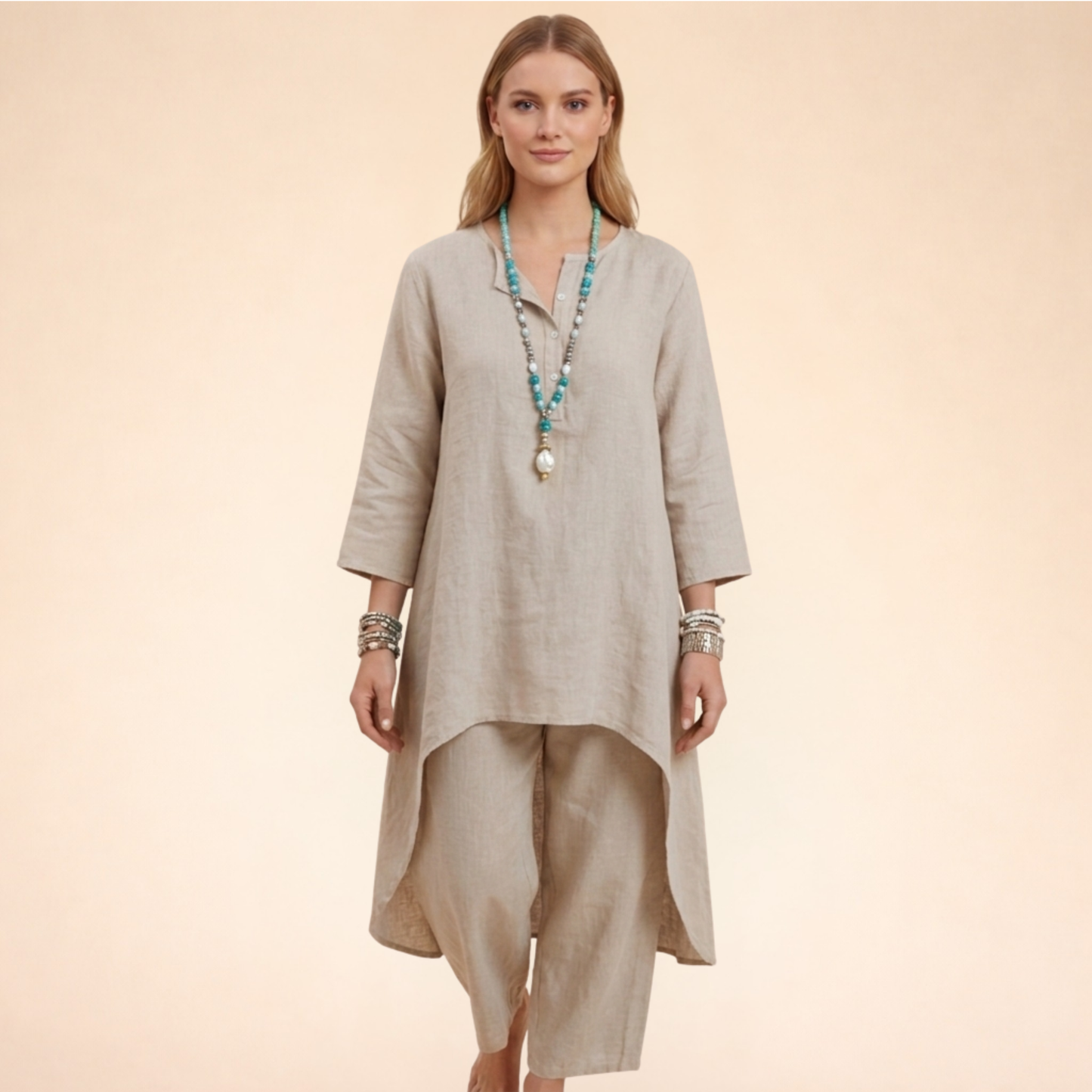 Beige - A woman modelling a light-coloured, relaxed-fit resort tunic top featuring a split neckline, three-quarter sleeves, and a dramatic high-low hemline.