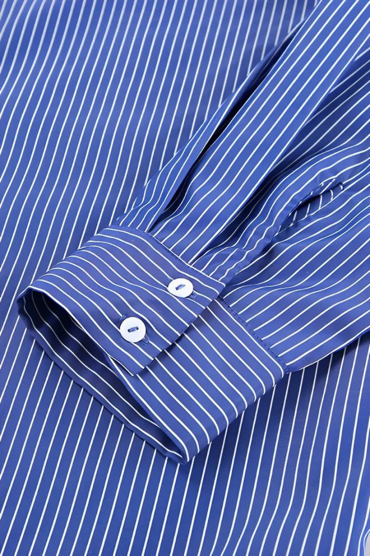 Woman in oversized blue and white striped shirt with black pants