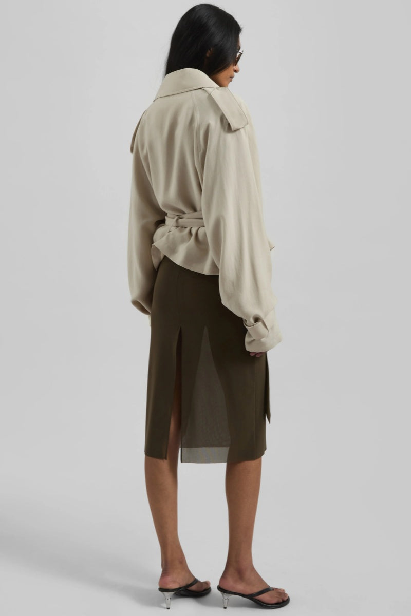 Women's cropped wrap trench jacket featuring a self-tie waist belt, wide lapels, shoulder epaulettes, and adjustable cuff straps in a fluid, relaxed fit.