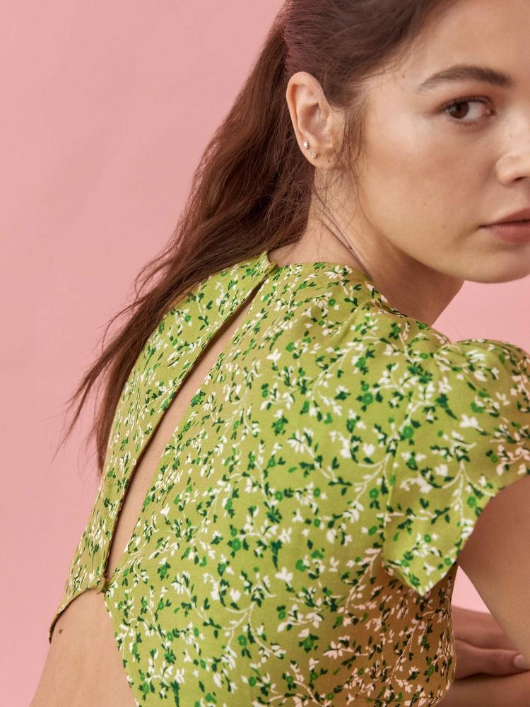 Woman in green floral midi dress with thigh-high slit