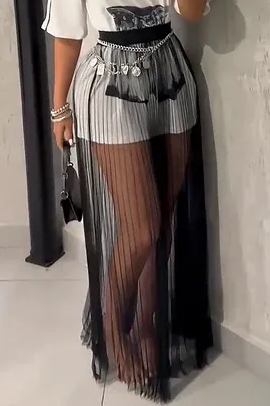 Skirt - A woman taking a mirror selfie wearing a sheer black vertically pleated maxi skirt layered over light shorts, paired with a graphic t-shirt and chain belt.