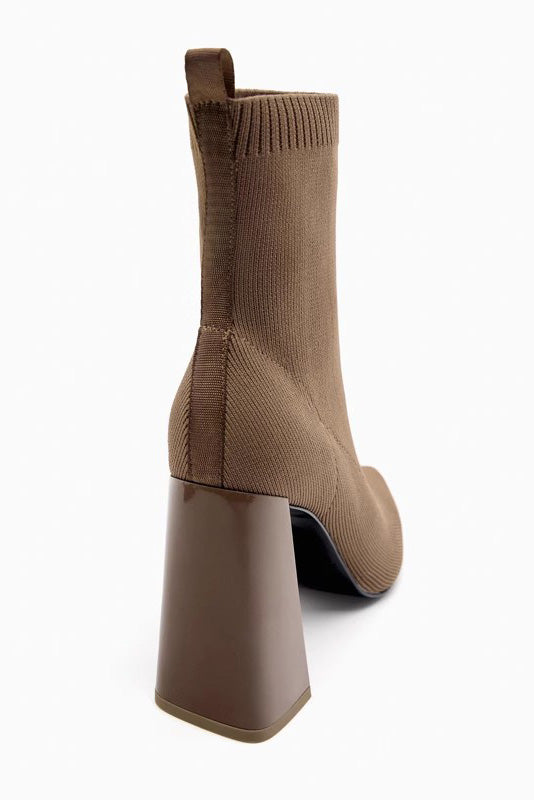 Brown - Women's black ribbed knit ankle sock boots featuring a pointed toe and a shiny block heel.
