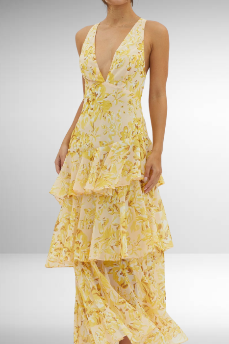 Yellow - A woman wearing a vibrant teal and blue abstract floral print maxi dress featuring a deep V-neckline and a dramatic tiered ruffle skirt.