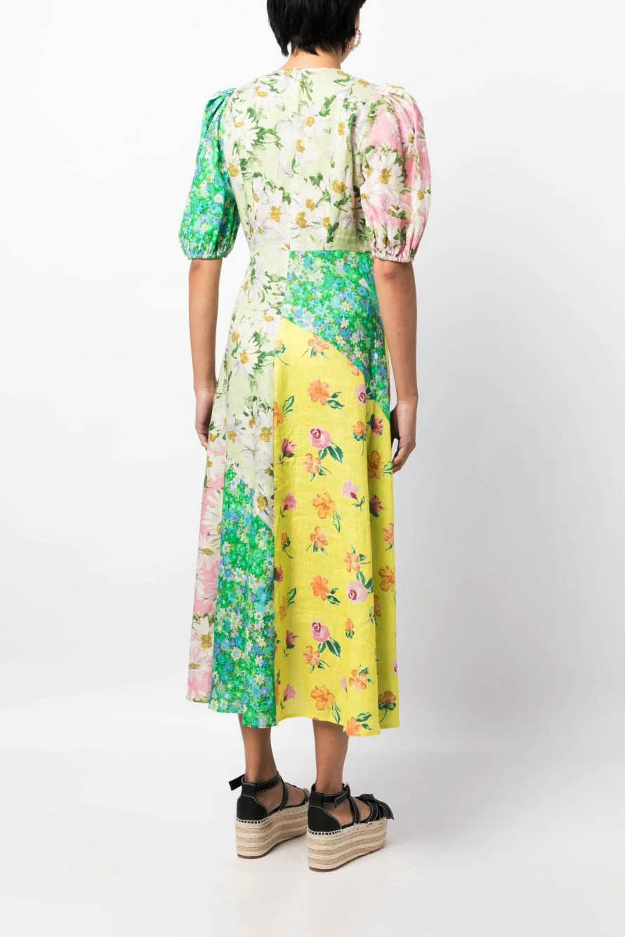 A woman models a short-sleeve, crewneck midi dress with a white background and a colorful, illustrative print of marine life including jellyfish, coral, and seashells.