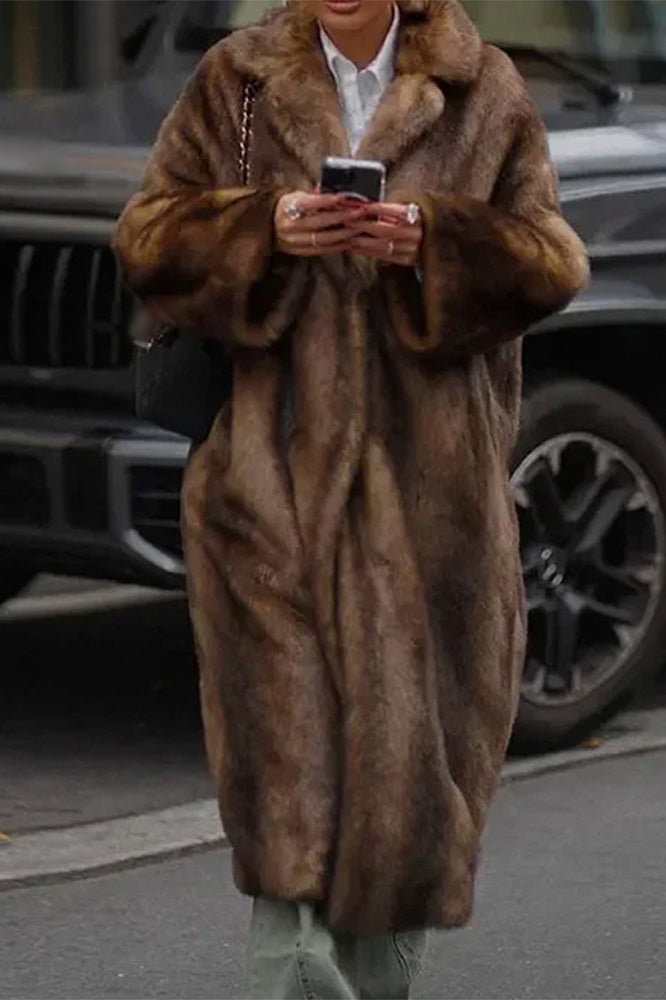 Brown - A woman modeling a long, heavyweight brown faux fur coat with a wide lapel collar, styled over a white collared shirt.