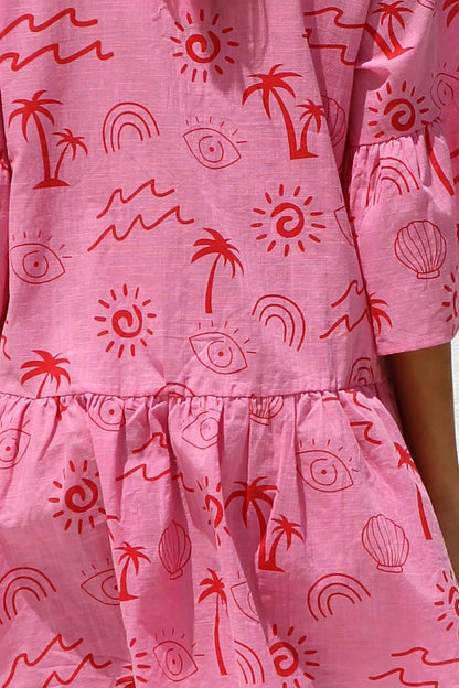 Woman in pink linen mini dress with red print