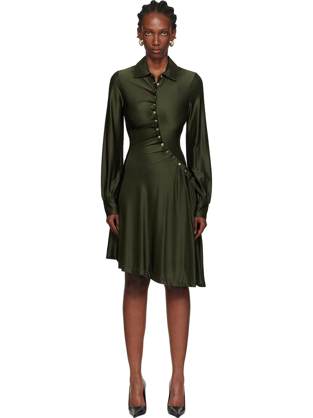 Black - Full-length view of a woman wearing a long-sleeved, knee-length shirt dress in a lustrous olive green, featuring an asymmetrical button front, ruched detailing, and an uneven hem.
