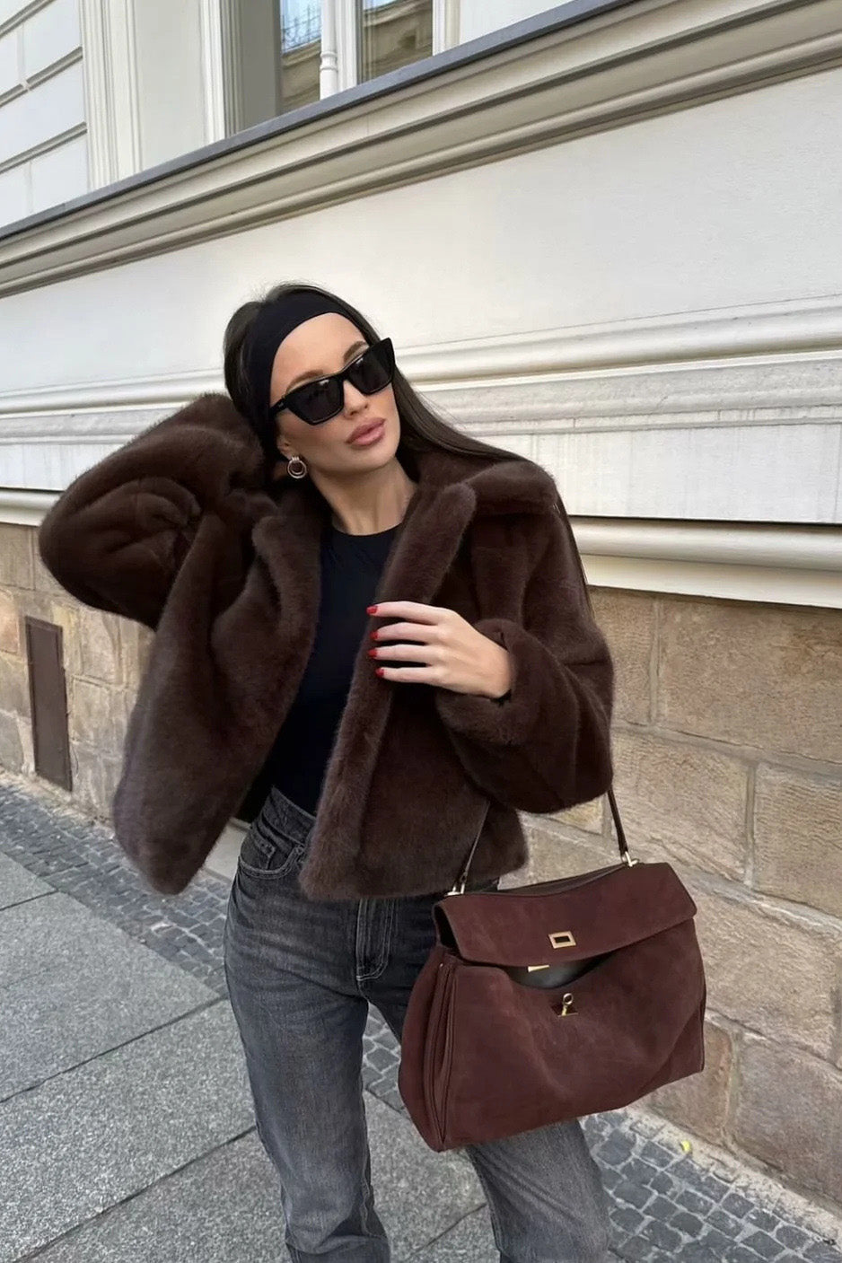 Brown - A woman standing outdoors on stone steps wearing a dark brown, plush faux fur cropped jacket with a wide collar, styled with a mini skirt and tall black boots.