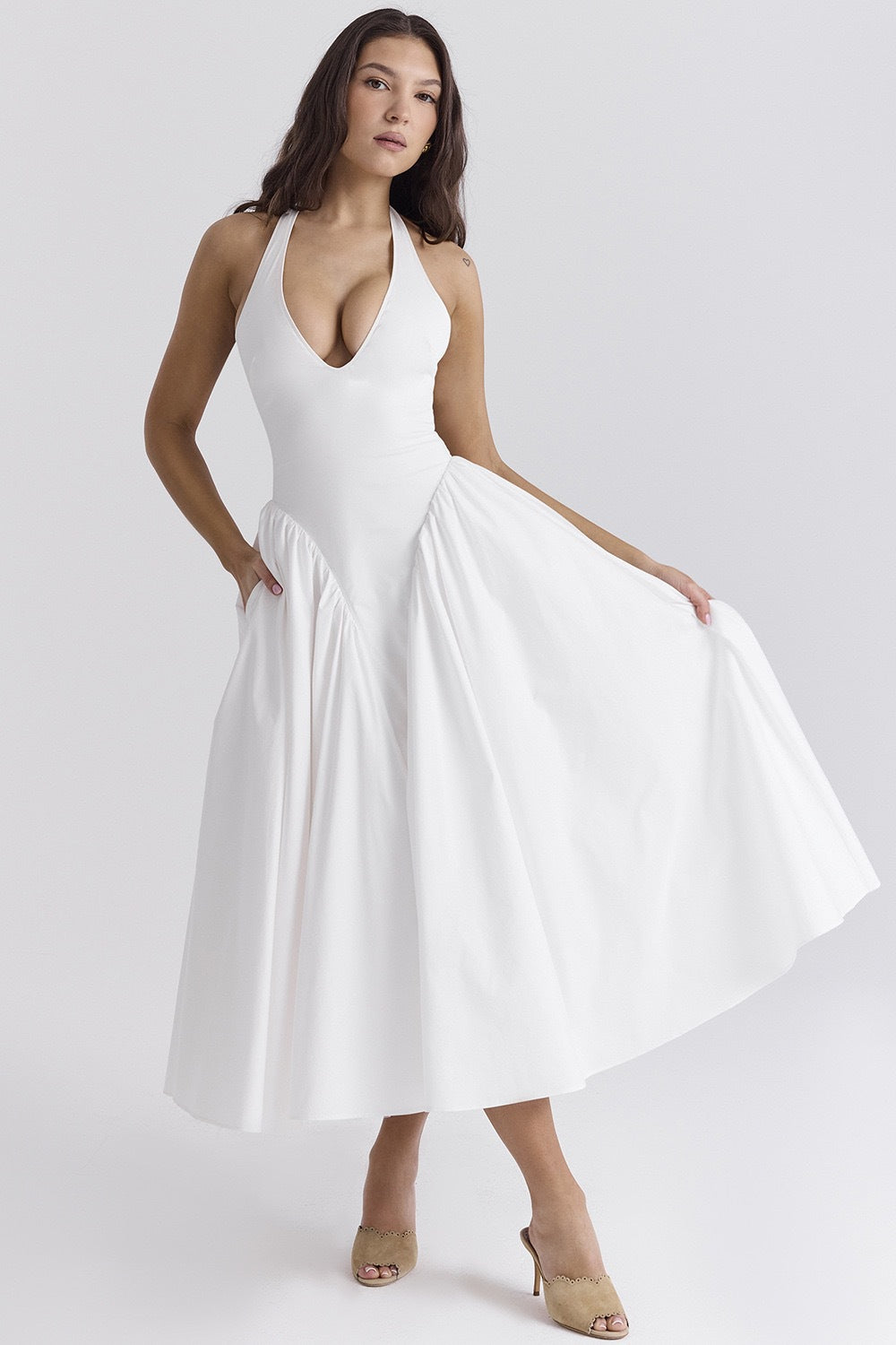 White - A woman models a white sleeveless midi dress with a deep V-neck halter top, a fitted bodice, and a full, gathered A-line skirt, against a plain white background.