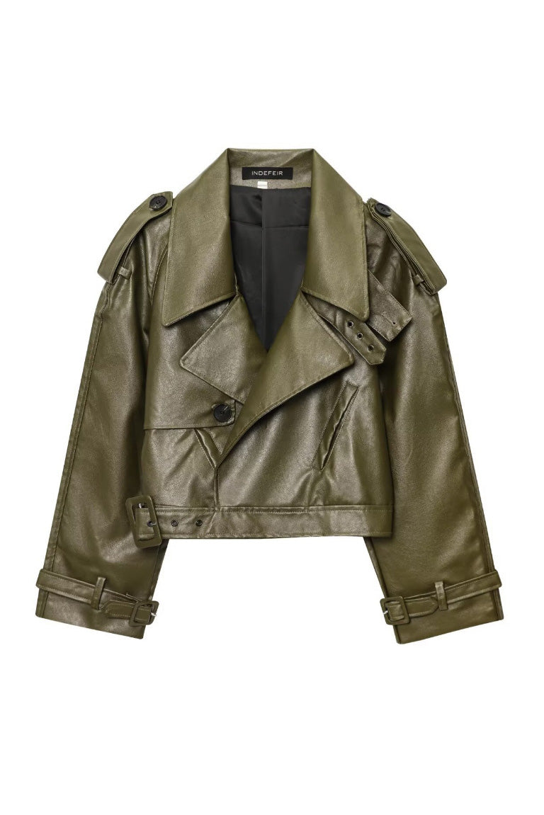 Green - A woman wearing a burgundy oversized faux leather jacket with wide lapels, belted cuffs, and voluminous sleeves, styled over a black turtleneck in a city setting.