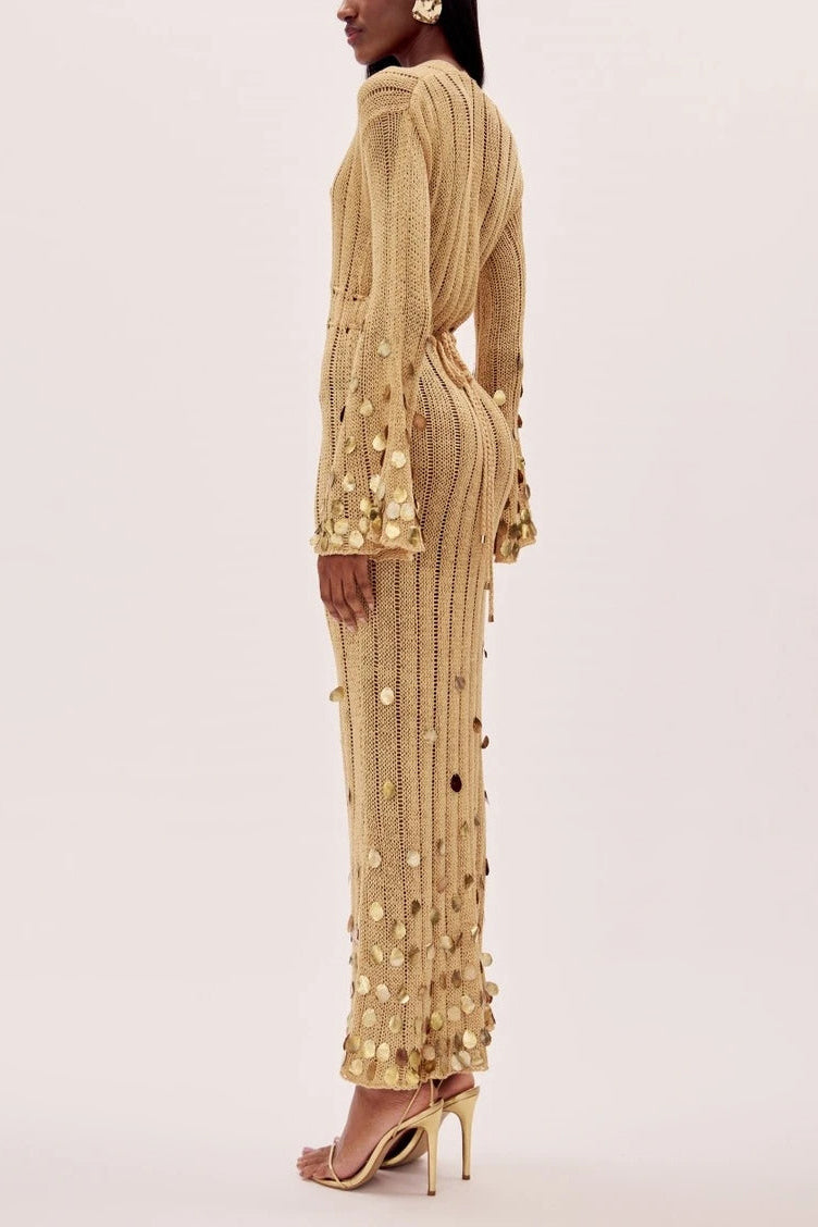 Yellow - Full-length view of a model wearing a long-sleeve, gold open-knit maxi dress with a plunging V-neckline, flared cuffs, and large gold sequin embellishments.