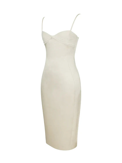 A woman modeling a fitted cream-colored midi dress with spaghetti straps and a ruched sweetheart neckline.