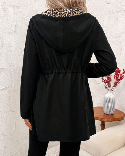 Black Polka - Women's mid-length red zip-up anorak jacket worn open to reveal a bold leopard print interior lining, featuring front pockets and an internal drawstring waist.