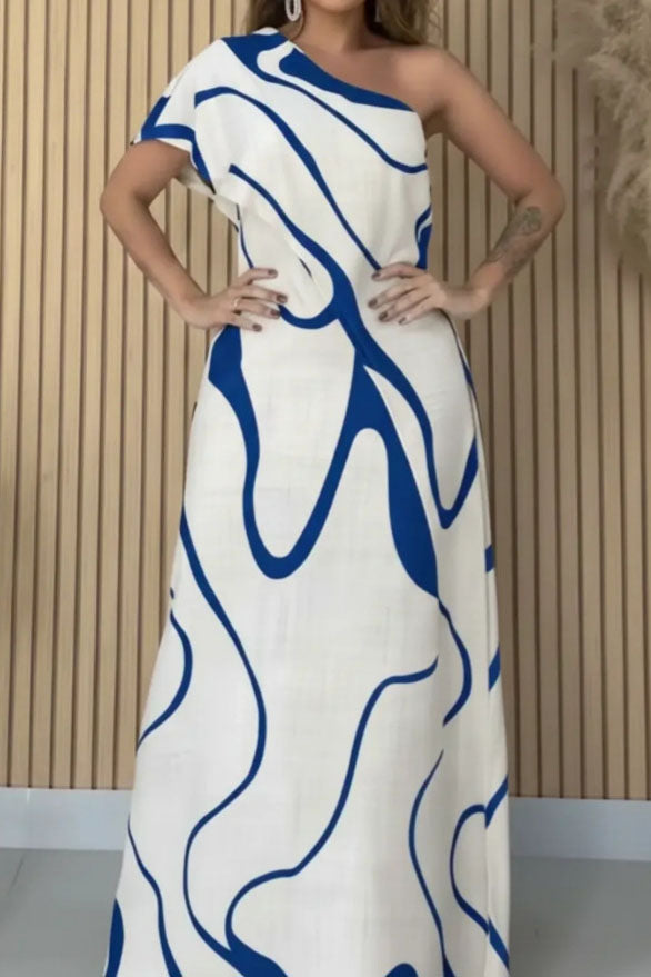 Woman in cream and black abstract print one-shoulder maxi dress