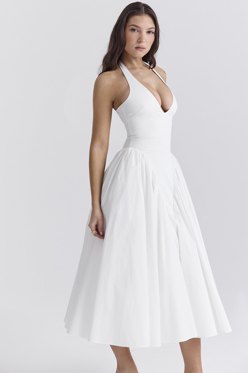 White - A woman models a white sleeveless midi dress with a deep V-neck halter top, a fitted bodice, and a full, gathered A-line skirt, against a plain white background.