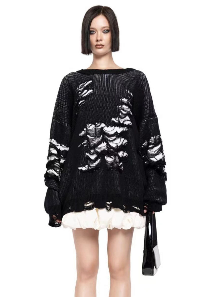 Black - Model wearing a women's oversized black knit jumper featuring heavy distressed laddering and cut-outs, styled with a white mini skirt.