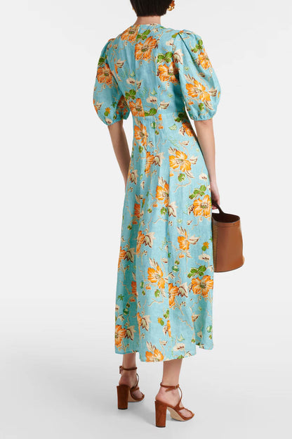 A woman models a short-sleeve, crewneck midi dress with a white background and a colorful, illustrative print of marine life including jellyfish, coral, and seashells.
