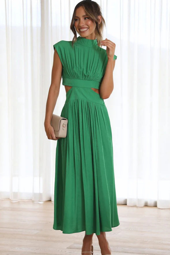 Green - A woman models a pale yellow, high-neck, sleeveless midi dress with a ruched bodice, a side waist cut-out, and a full, flowing A-line skirt, standing outdoors.