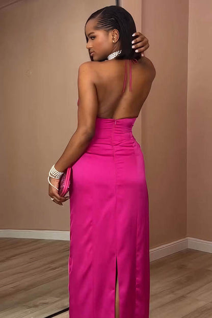 Pink - A woman modeling a formal, bright pink satin maxi gown featuring a halter neckline, a side cutout at the waist, and elegant draped detailing.