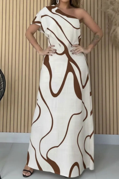 Woman in cream and black abstract print one-shoulder maxi dress
