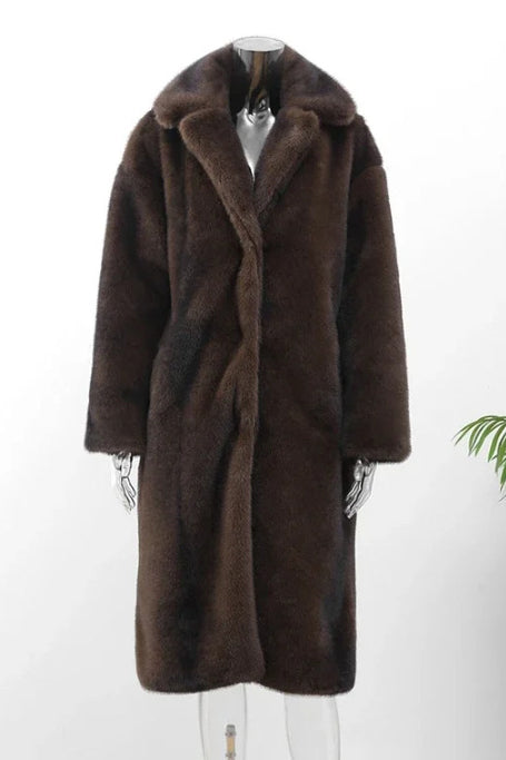Brown - A woman modeling a long, heavyweight brown faux fur coat with a wide lapel collar, styled over a white collared shirt.