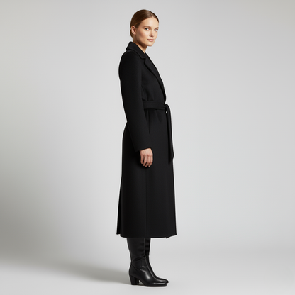 Schwarz - Women's elegant black tailored maxi wrap coat featuring wide notch lapels and a self-tie waist belt, worn by a model over black leather boots against a light grey background.
