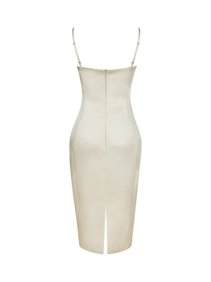 A woman modeling a fitted cream-colored midi dress with spaghetti straps and a ruched sweetheart neckline.