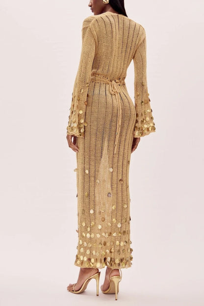 Yellow - Full-length view of a model wearing a long-sleeve, gold open-knit maxi dress with a plunging V-neckline, flared cuffs, and large gold sequin embellishments.