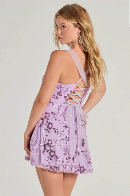 Purple - A woman stands in a full-length pose wearing a lavender, sleeveless, A-line mini dress with a square neckline, featuring all-over tonal purple sequin floral embroidery, against a plain studio background.