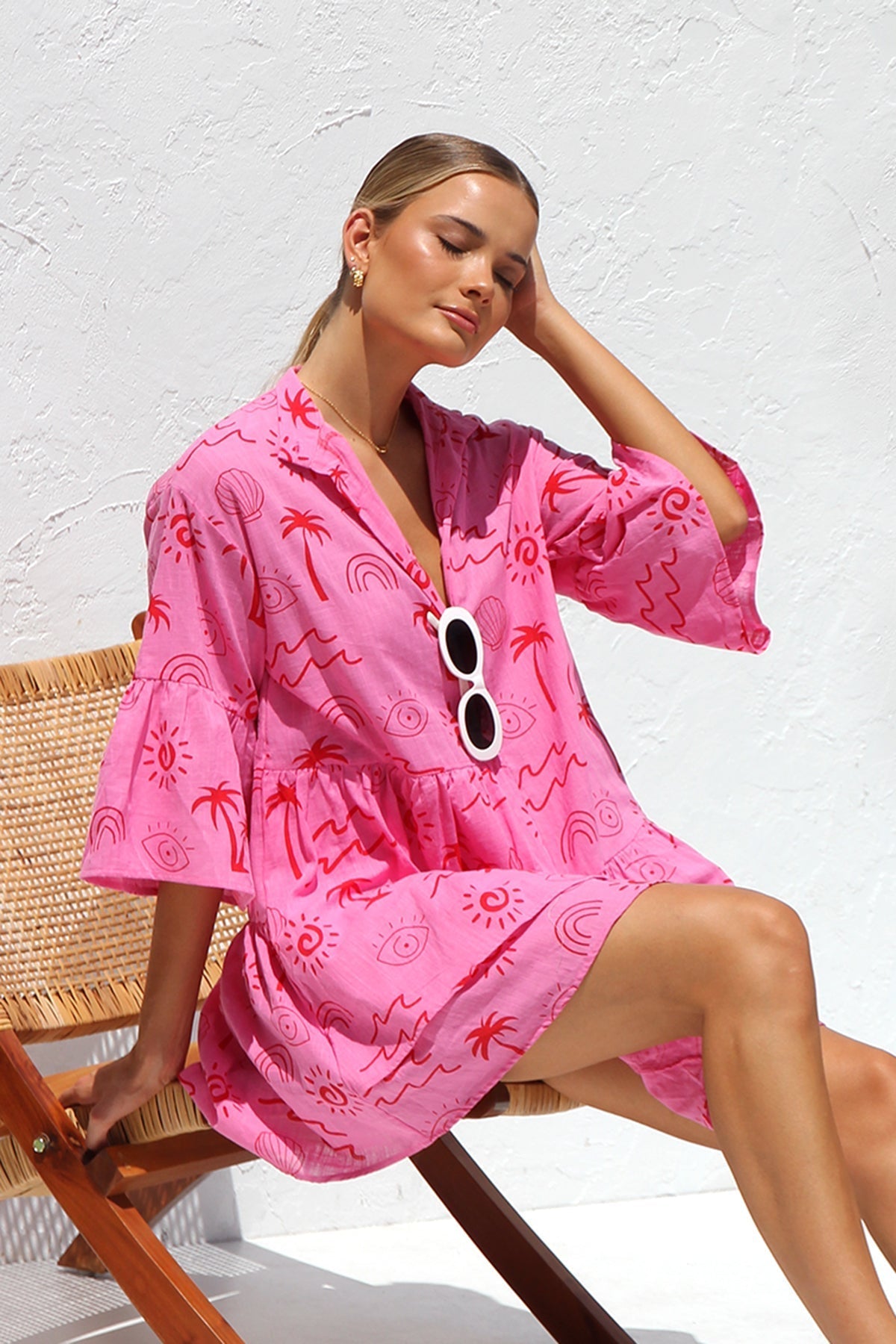Woman in pink linen mini dress with red print