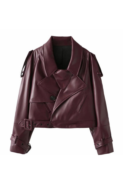 Red - A woman wearing a burgundy oversized faux leather jacket with wide lapels, belted cuffs, and voluminous sleeves, styled over a black turtleneck in a city setting.