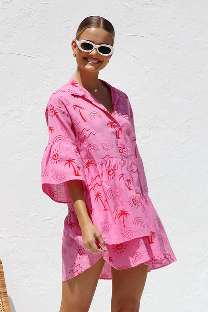 Woman in pink linen mini dress with red print