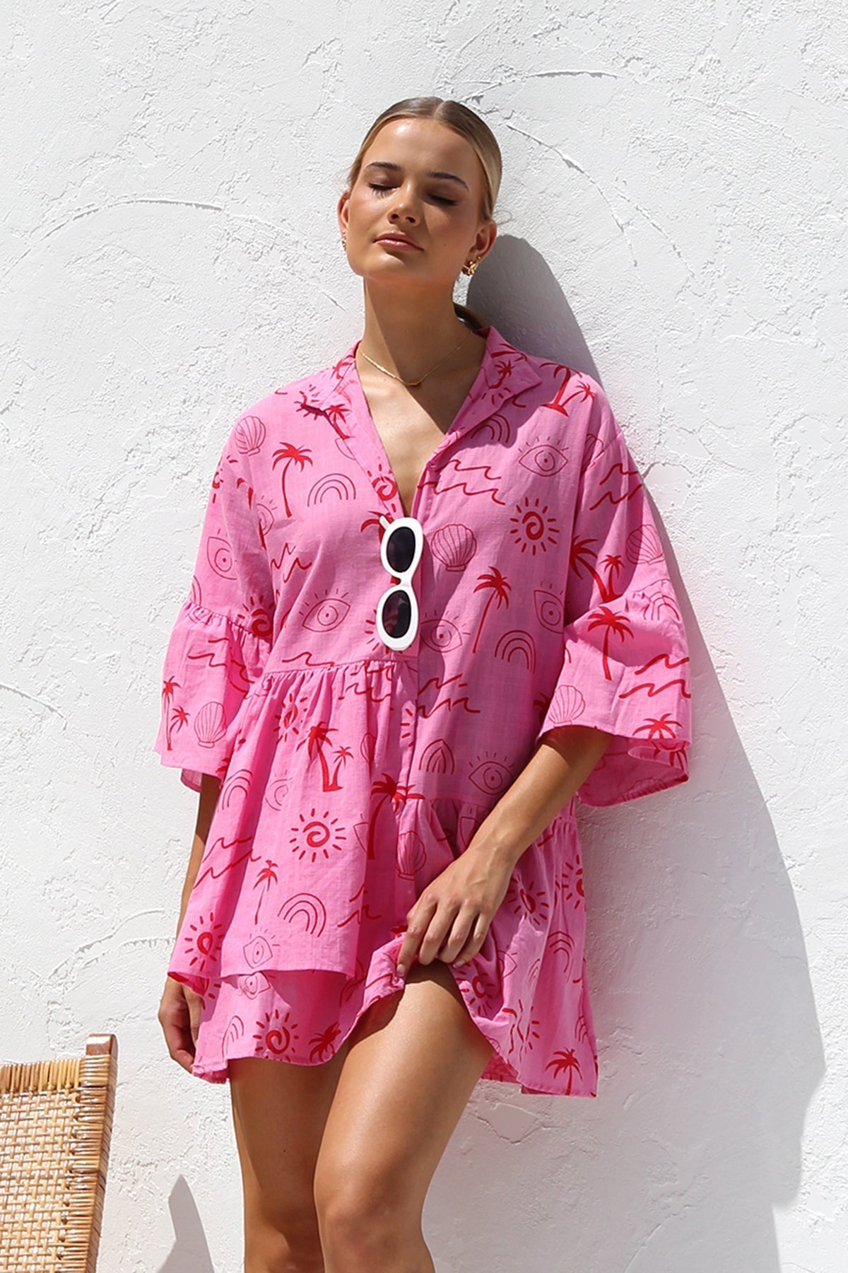 Woman in pink linen mini dress with red print