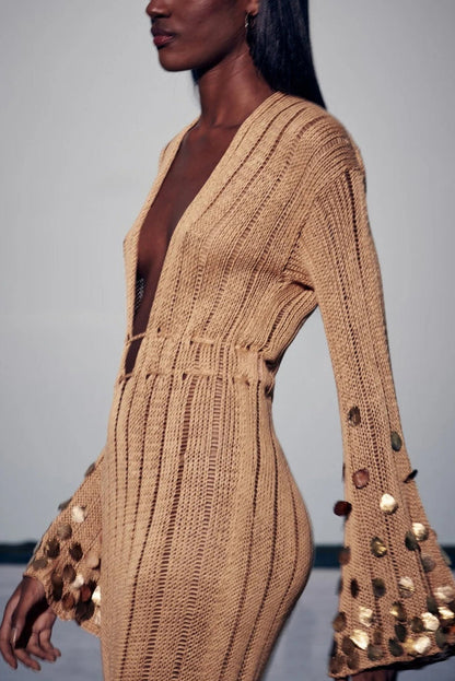 Yellow - Full-length view of a model wearing a long-sleeve, gold open-knit maxi dress with a plunging V-neckline, flared cuffs, and large gold sequin embellishments.