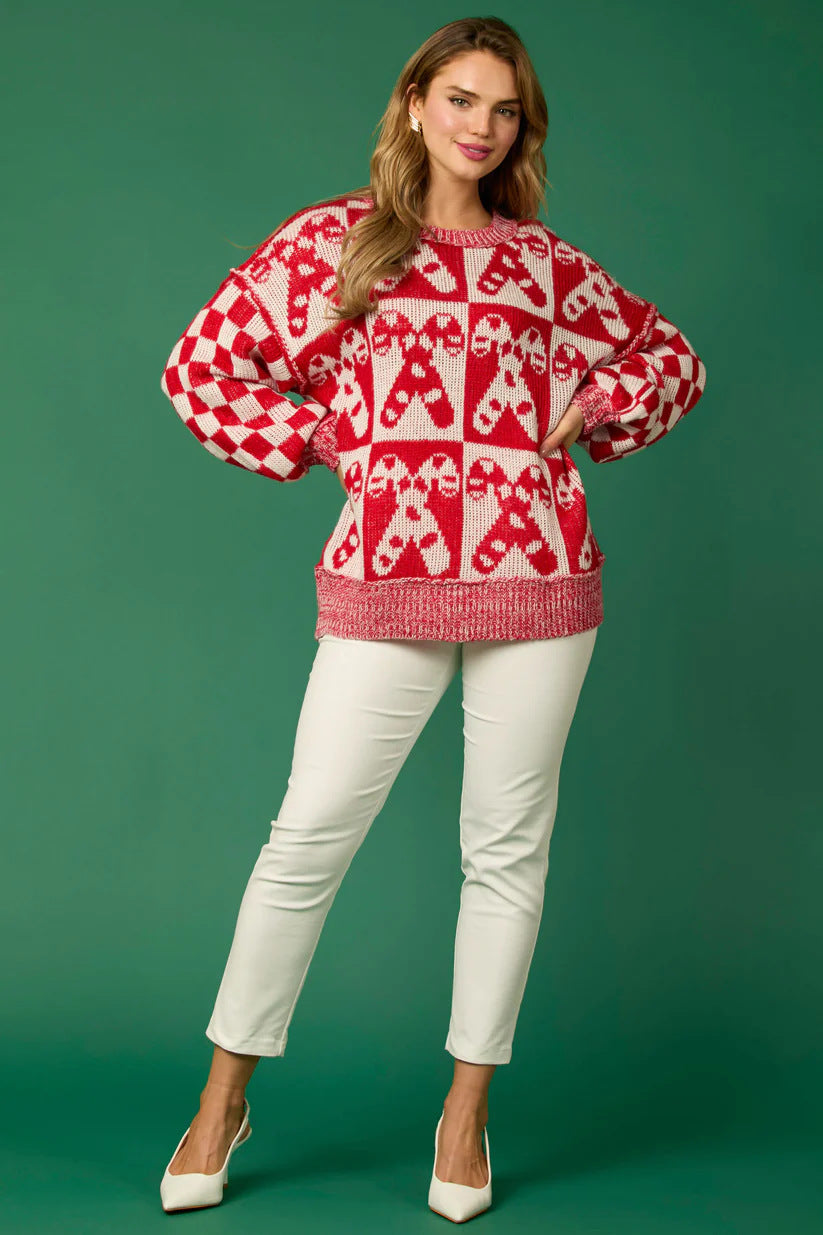 Red - Women's oversized knit jumper featuring a festive red and white candy cane and checkerboard pattern, styled with drop shoulders and a crew neckline.