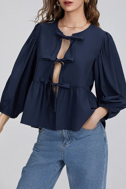 Dark Blue - Women's crisp white blouse featuring a split front with three bow ties, voluminous 3/4 length puff sleeves, and a gathered peplum hem.