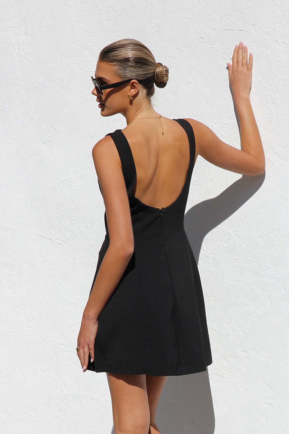 Woman in black crepe A-line mini dress