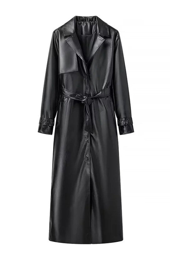 Black - A woman walking down a city street wearing a long, deep burgundy faux leather trench coat with a tie belt, styled over a black turtleneck and black leggings.