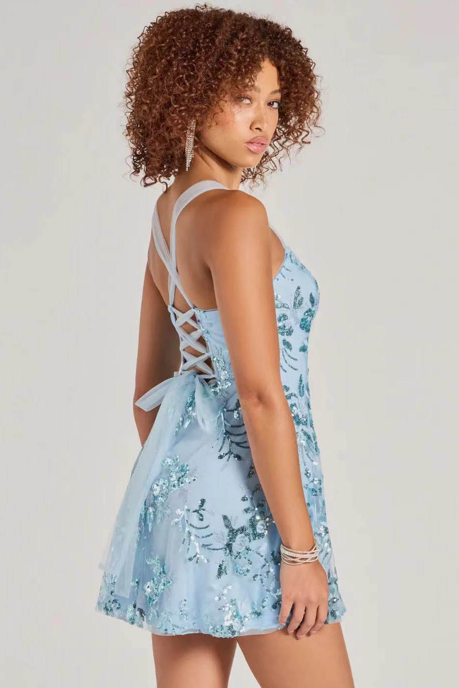 Blue - A woman stands in a full-length pose wearing a lavender, sleeveless, A-line mini dress with a square neckline, featuring all-over tonal purple sequin floral embroidery, against a plain studio background.