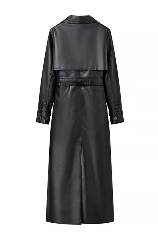 Black - A woman walking down a city street wearing a long, deep burgundy faux leather trench coat with a tie belt, styled over a black turtleneck and black leggings.