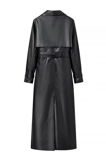 Black - A woman walking down a city street wearing a long, deep burgundy faux leather trench coat with a tie belt, styled over a black turtleneck and black leggings.