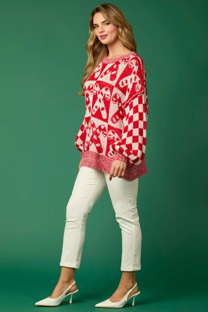 Red - Women's oversized knit jumper featuring a festive red and white candy cane and checkerboard pattern, styled with drop shoulders and a crew neckline.
