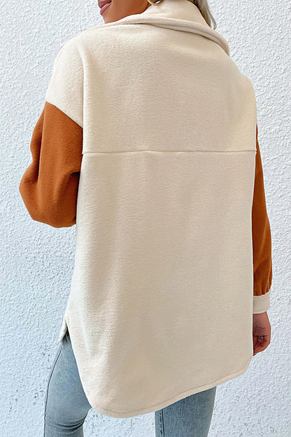 Cream - A woman wearing a relaxed fit, button-front shirt jacket featuring a cream body with contrasting rust orange sleeves and chest pocket flaps, styled open over a white crop top and jeans.