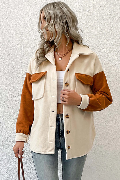 Cream - A woman wearing a relaxed fit, button-front shirt jacket featuring a cream body with contrasting rust orange sleeves and chest pocket flaps, styled open over a white crop top and jeans.