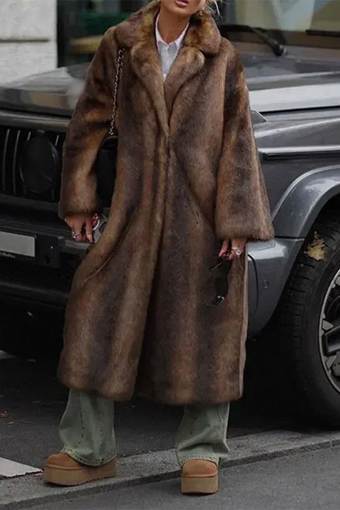 Brown - A woman modeling a long, heavyweight brown faux fur coat with a wide lapel collar, styled over a white collared shirt.