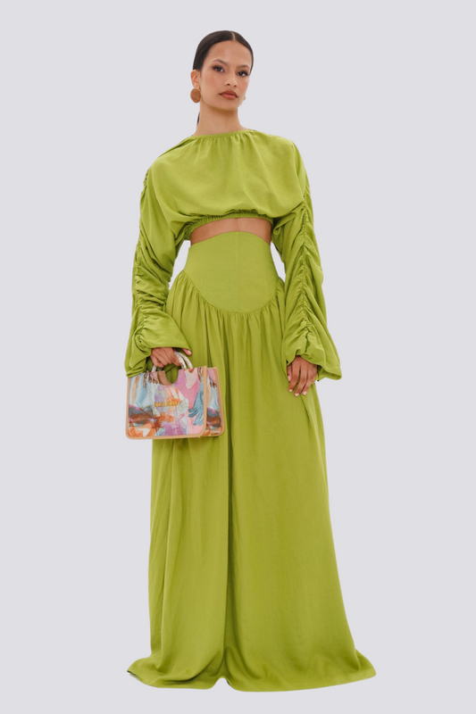 Green - Full-length studio shot of a woman wearing a vibrant lime green two-piece set, featuring a long-sleeved cropped top with ruched arms and matching high-waisted, wide-leg trousers.