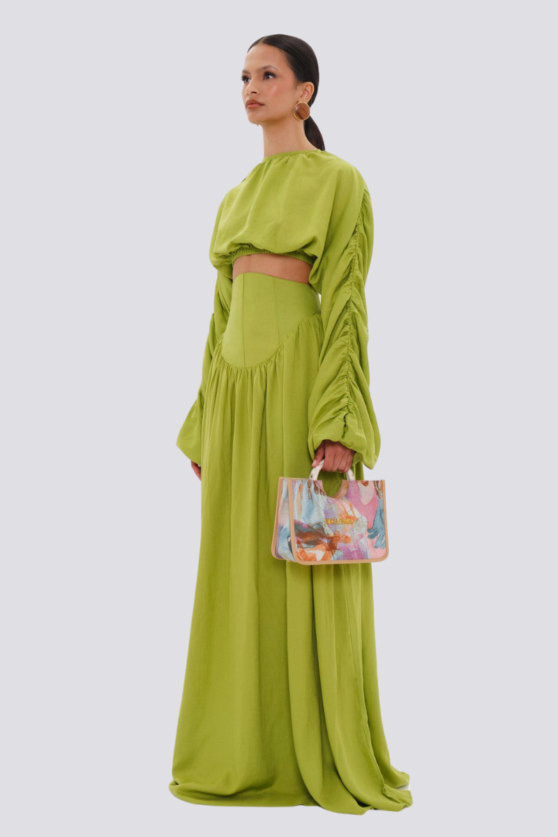 Green - Full-length studio shot of a woman wearing a vibrant lime green two-piece set, featuring a long-sleeved cropped top with ruched arms and matching high-waisted, wide-leg trousers.